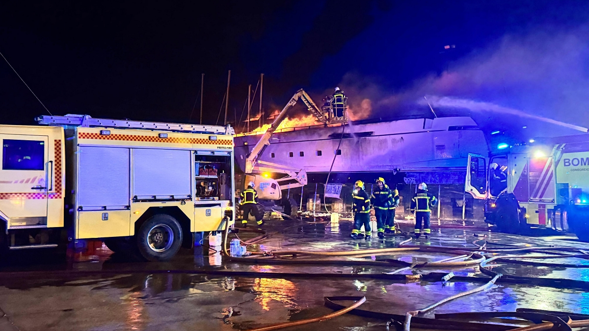 Bomberos actúan en la embarcación incendiada en el astillero del puerto de Sotogrande