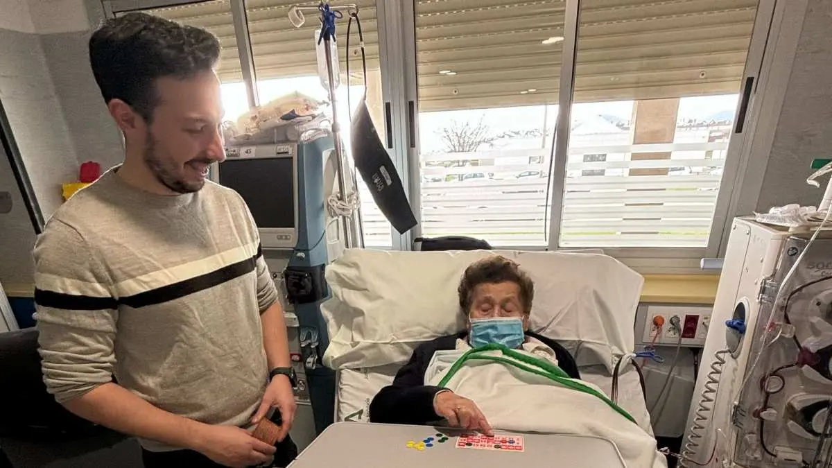 Un joven de la Hermandad, en plena partida de bingo con una de las pacientes