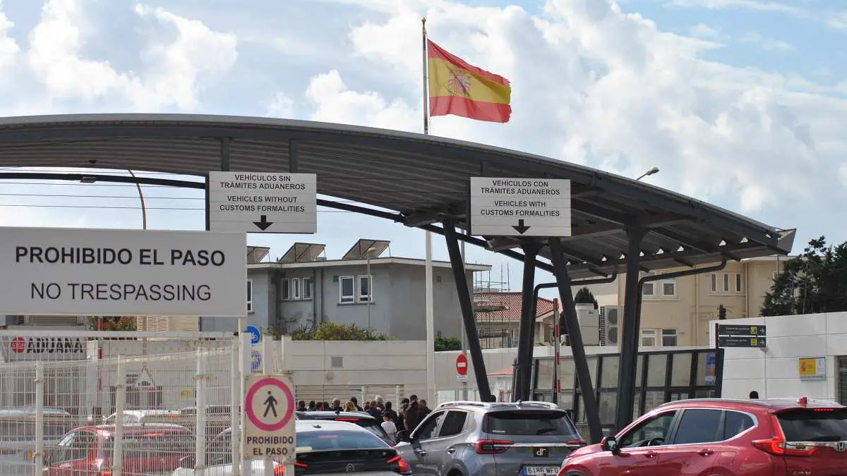 Acceso de vehículos a Gibraltar, con la bandera española al fondo