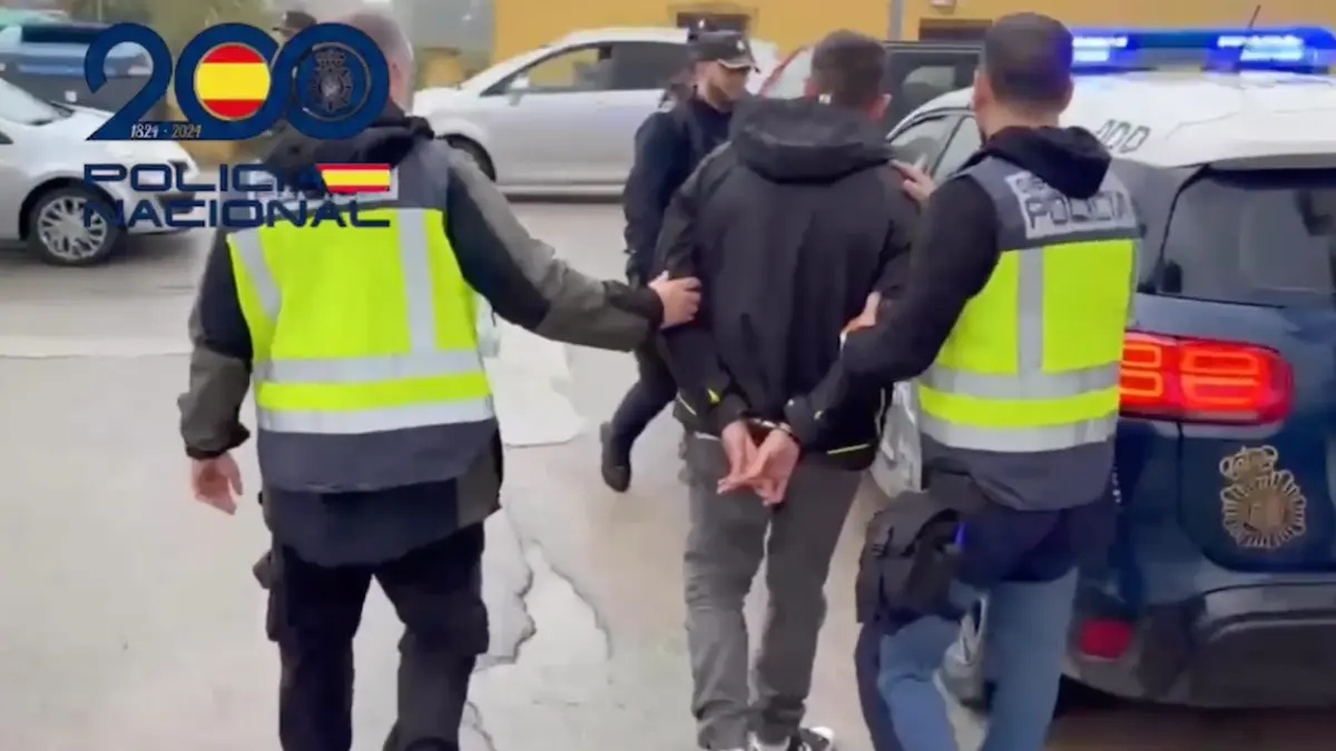Agentes de la Policía Local conducen al vehículo a uno de los detenidos