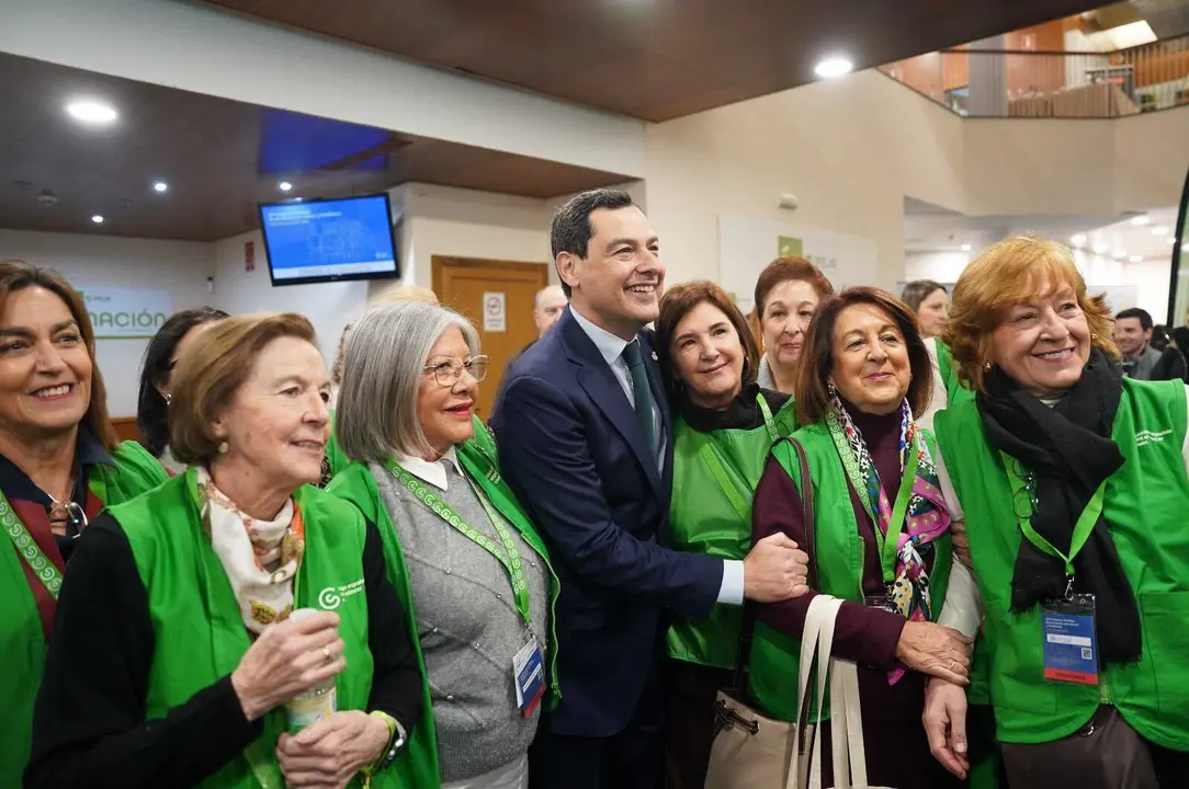 El presidente de la Junta de Andaluc&iacute;a, Juanma Moreno, junto a voluntarios de la Asociaci&oacute;n Espa&ntilde;ola Contra el C&aacute;ncer durante un acto de apoyo a los programas de prevenci&oacute;n y cribado impulsados en la comunidad.