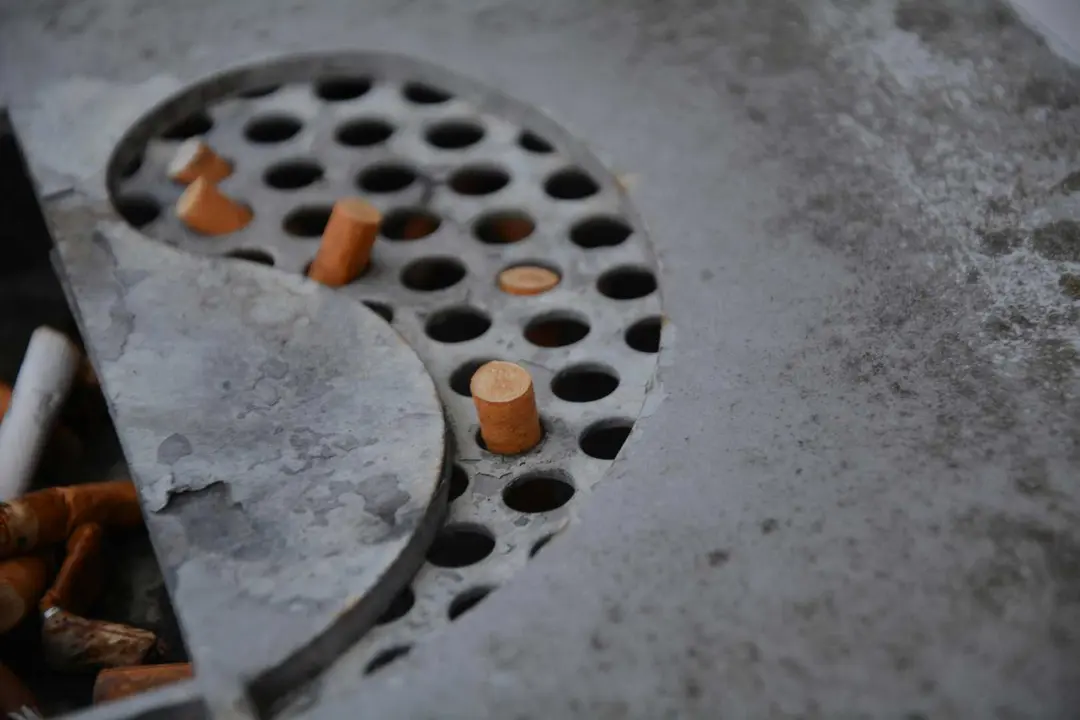 Restos de colillas en un cenicero durante una pausa laboral fuera del puesto de trabajo