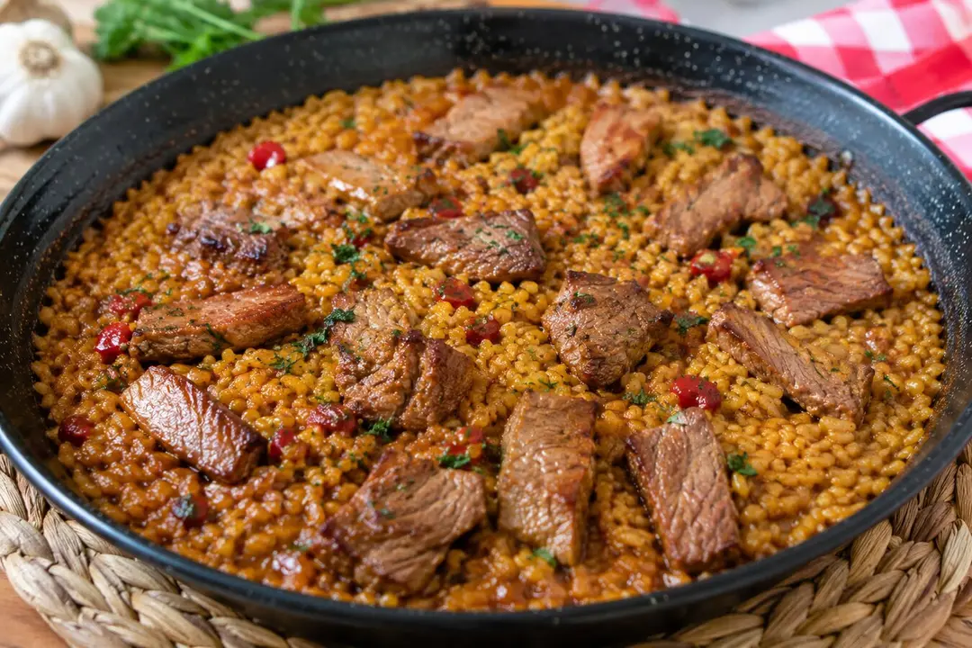 Arroz meloso con pluma ib&eacute;rica servido en sart&eacute;n.