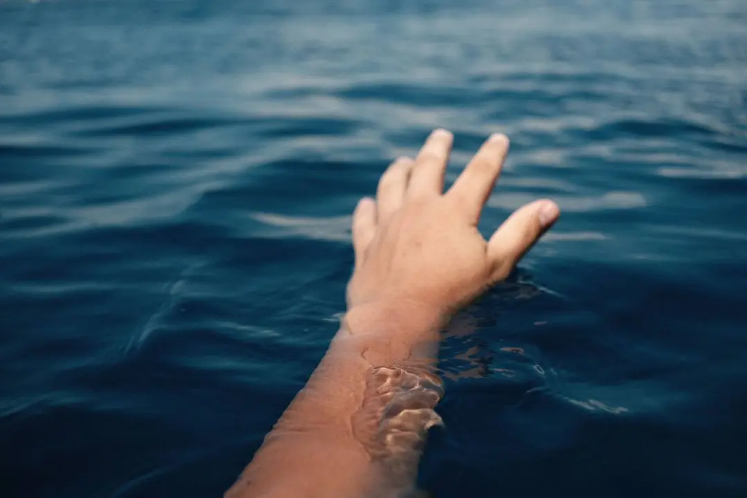 Una mano emerge del agua durante una situaci&oacute;n de emergencia en el mar