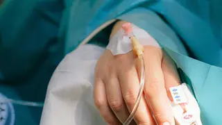 Paciente hospitalizado con v&iacute;a intravenosa durante un procedimiento m&eacute;dico.