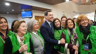 El presidente de la Junta de Andaluc&iacute;a, Juanma Moreno, junto a voluntarios de la Asociaci&oacute;n Espa&ntilde;ola Contra el C&aacute;ncer durante un acto de apoyo a los programas de prevenci&oacute;n y cribado impulsados en la comunidad.