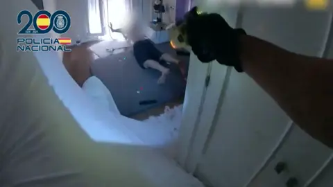 Momento en el que los agentes detienen al agresor en la vivienda de La Línea. FOTO: Polic&iacute;a Nacional.
