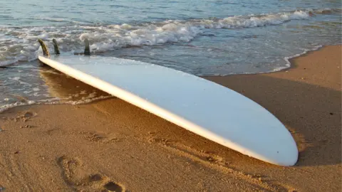 Una tabla de surf en la orilla de un playa