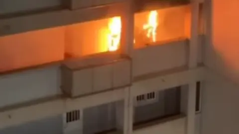 Las llamas salen por uno de los balcones de la vivienda afectada. FOTO - Vídeo de la Royal Police
