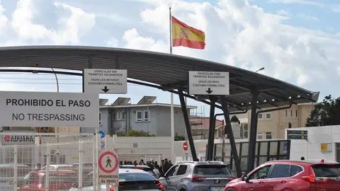 Acceso de vehículos a Gibraltar, con la bandera española al fondo