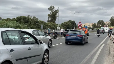 La moto y el coche implicados y el motorista, a la derecha, reponiéndose del impacto
