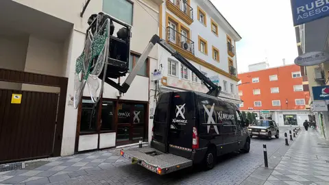 Operarios trabajan en la instalaci&oacute;n del alumbrado de Carnaval en la calle San Antonio de Algeciras