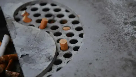 Restos de colillas en un cenicero durante una pausa laboral fuera del puesto de trabajo