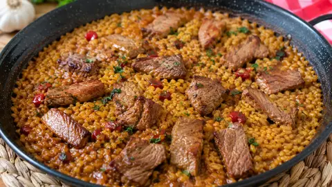 Arroz meloso con pluma ib&eacute;rica servido en sart&eacute;n.